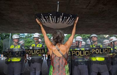 Woman with upturned umbrella at water rationing protest in Sao Paulo (photo credit National Geographic)